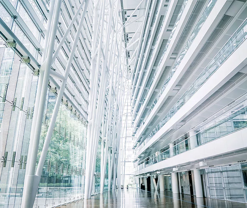 Vue intérieure d’un édifice avec des colonnes blanches et plusieurs fenêtres.