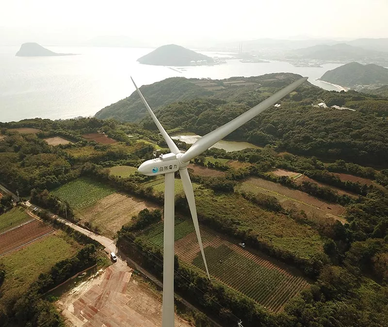 Une éolienne avec vue sur l'eau.