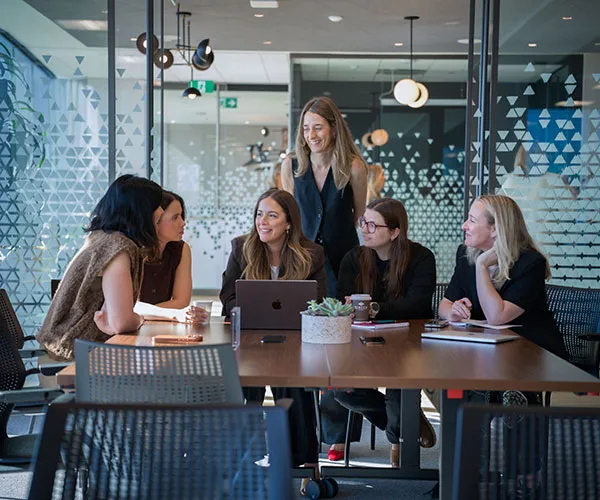 Femmes assises autour d'une table en conversation.